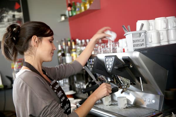 Waitress serving coffee from machine